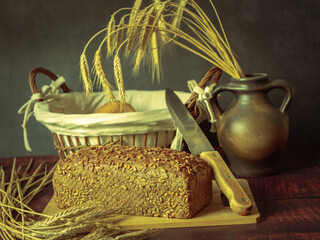 Rustic still life in antique style with bread and ears of wheat . - 651622067