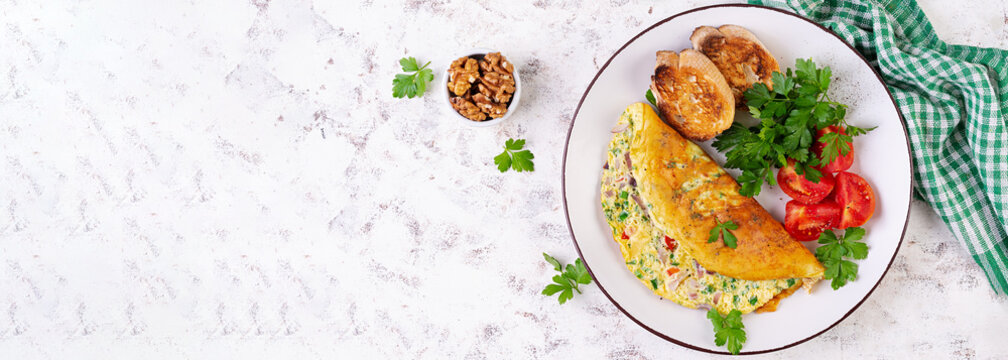 Omelette with tomatoes, cheese and red onion on white plate.  Frittata - italian omelet. Top view, banner