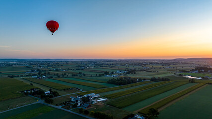 An Aerial View of a Red Hot Air Balloon, Floating Across Rural Pennsylvania, on a Sunny Morning, in the Summer