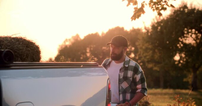 Portrait of Caucasian male farmer loading hay bays into the pickup bed