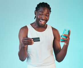 Black man, happy with smartphone and credit card, e commerce and payment success or win on blue background. Fintech, online shopping and website discount, giveaway with customer experience in studio