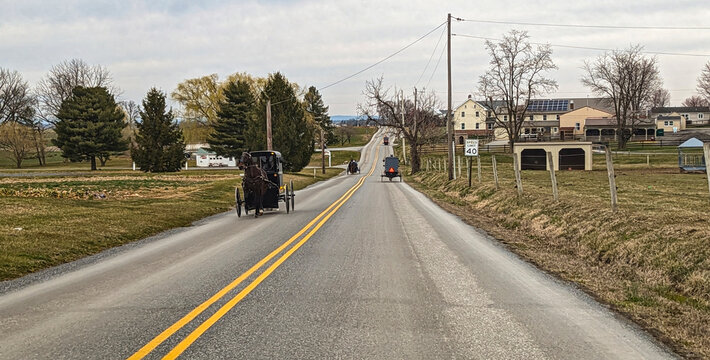 A Drone View of an Amish Horse and Buggy Traveling Along a Country Road on a Summer Day