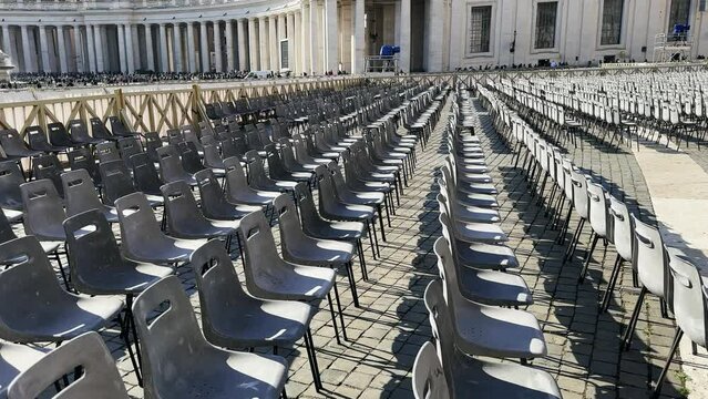 Empty row of chairs set up at Saint Peter square in Vatican as preparation for Eastern holiday ceremony on spring sunny day