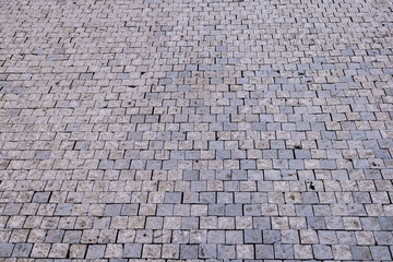 An area of checkered, stone pavement running backwards