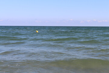 A body of water with waves and a yellow ball in it