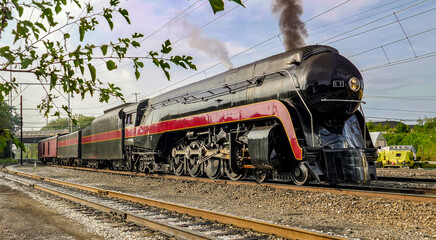 A Restored Streamlined Steam Locomotive, with Support Consist, Blowing Black Smoke, While Arriving at the Strasburg Rail Road