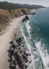 Wide aerial shot of a beach looking down the shoreline with craggy rocks in the ocean