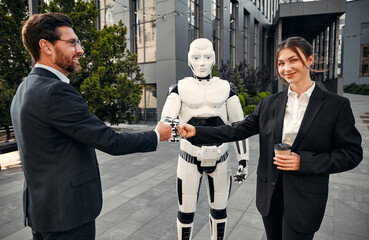 Robot with businessmen on the street near the building