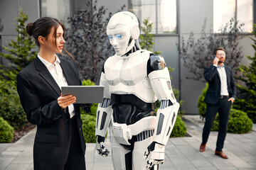Robot with businessmen on the street near the building
