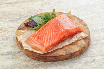 Raw salmon fillet over board