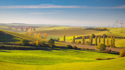 Autumn sunny rural landscape with a row of colored trees. The Turiec region of Slovakia, Europe.