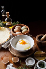 Ingredients for preparing the cheese and egg mass for filling the tart, set on the table, close-up view.