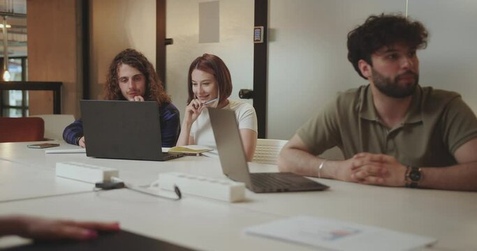 Beautiful couple, colleagues, working together at modern office, using lap top.
