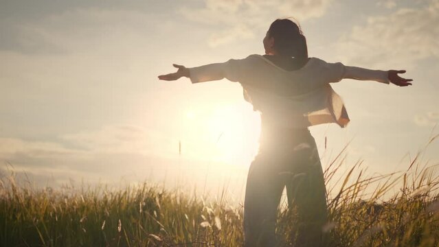 Happy smiling young woman enjoying nature. Young asian woman having fun in the meadow. freedom concept. Sunset
