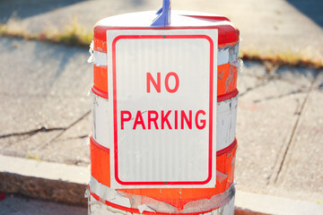 No Parking sign, rusted and aged, against a blurred urban background, conveying urban 
