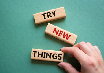 Try new Things symbol. Concept words Try new Things on wooden blocks. Businessman hand. Beautiful grey green background. Business and Try new Things concept. Copy space.