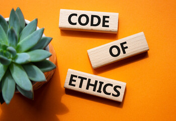 Code of ethics symbol. Concept words Code of ethics on wooden blocks. Beautiful orange background with succulent plant. Business and Code of ethics concept. Copy space. - obrazy, fototapety, plakaty