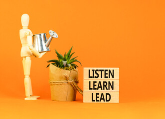 Listen learn lead symbol. Concept word Listen Learn Lead on beautiful wooden block. Businessman model. Beautiful orange table background. Business, education listen learn lead concept. Copy space.