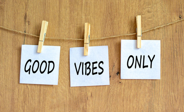 Good vibes only symbol. Concept word Good vibes only on beautiful white paper on wooden clothespin. Beautiful wooden table wooden background. Business motivational good vibes only concept. Copy space.