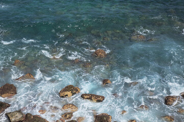 Sea foam under the tall cliff of northern eroded shore of Gran Canaria,  Galdar area 