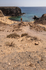 Natural white sandy beach landscape. Cove. Papagayo beach, Lanzarote. Beach and cliff. Turquoise ocean waters. Clear sky. Canary Islands, Spain