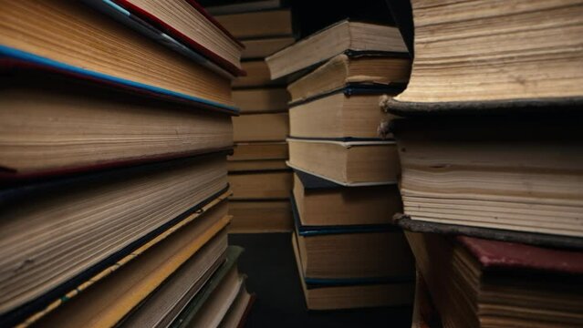 Library stack of old books, slider macro footage in antique shop, bookstore.