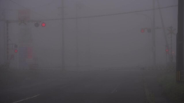 Hokkaido, Japan - September 3, 2023: A train passing a railroad crossing in a dense fog at dawn in Nemuro, Hokkaido, Japan
