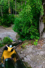 young boy on the slide in the forest playground