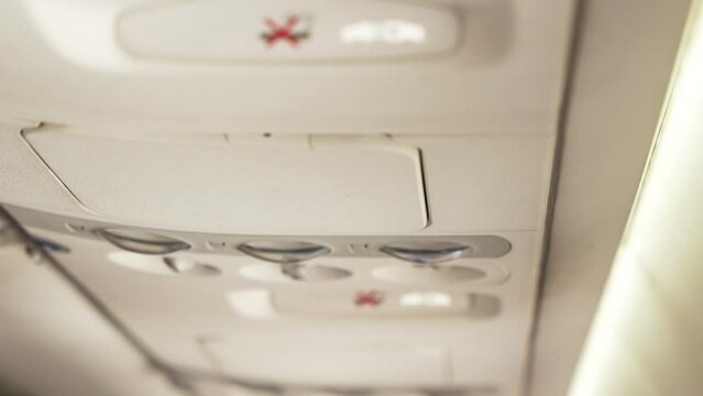 Close up of overhead console with no smoking and fasten seat belt sign on board in the modern passenger aircraft
