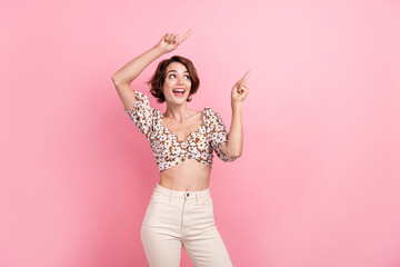 Portrait of cheerful lovely girl look indicate fingers empty space ad offer information isolated on pink color background