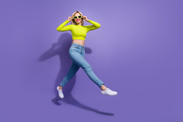 Fototapeta na wymiar Full length photo of optimistic girl wear stylish clothes going store center seasonal sale empty space isolated on purple color background