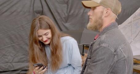 Young Woman looking at smartphone screen during dating. Issue of constant phone usage and its...