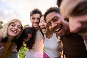 Crazy selfie of a group of young multirracial people embracing. Exited friends enjoying leisure and...
