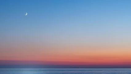 Fotobehang sunset over the sea © izzetugutmen