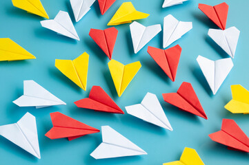 Yellow paper plane origami leading other white paper planes on blue background. Leadership concept....