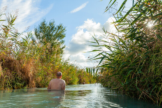 Person badet in schwefelhaltigem Wasser in Saturnia, Toskana, Italien