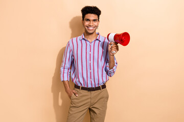 Portrait of friendly handsome guy with earrings dressed stylish shirt hold loudspeaker hand in...