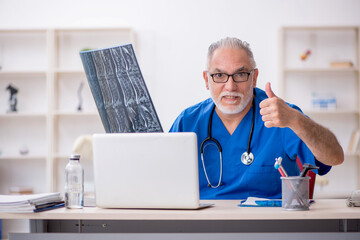 Old male doctor radiologist working in the clinic