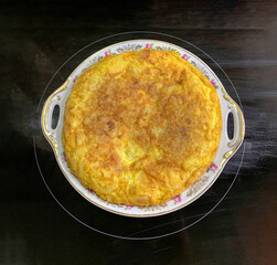 SPANISH POTATO OMELETTE ON A BLACK GLASS CERAMIC