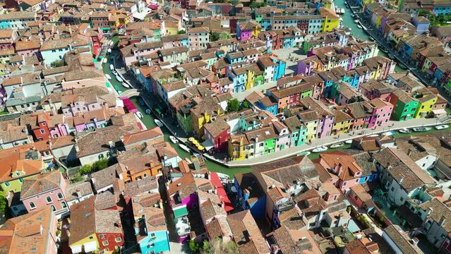 Aerial view of Burano colorful houses, along the Fondamenta embankment, featuring fishing boats and bridges, in the Venice province of the Veneto region, Italy