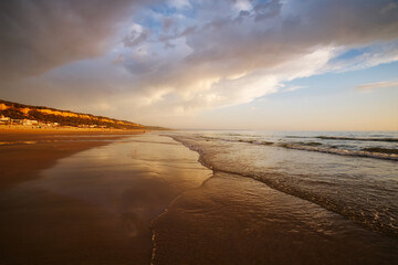 Atlantic ocean sunset with surging waves at Fonte da Telha beach, Costa da Caparica, Portugal