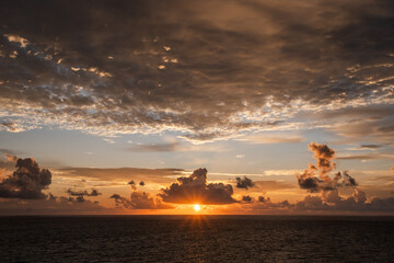 Fototapeta na wymiar Dramatic cloud sky during sunrise/sunset over the North Atlantic Ocean and Caribean Sea looks like the sky is on fire.