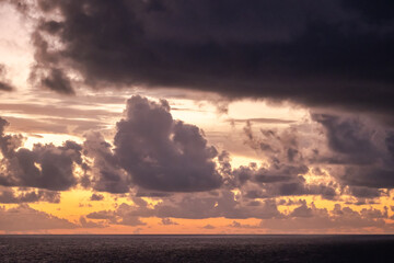 Dramatic cloud sky during sunrise/sunset over the North Atlantic Ocean and Caribean Sea looks like...