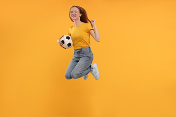 Emotional sports fan with ball jumping on yellow background
