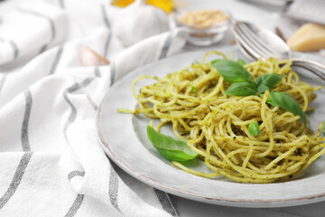 Delicious pasta with pesto sauce and basil on table, closeup. Space for text