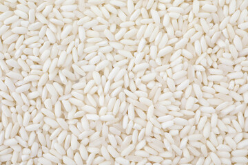 Raw polished rice as background, top view