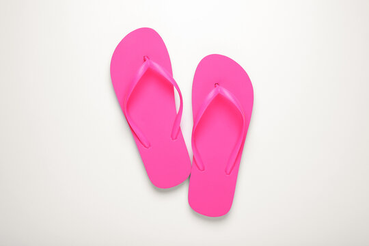 Stylish pink flip flops on white background, top view