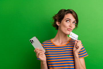 Photo portrait of attractive young woman look empty space gadget credit card wear trendy striped...