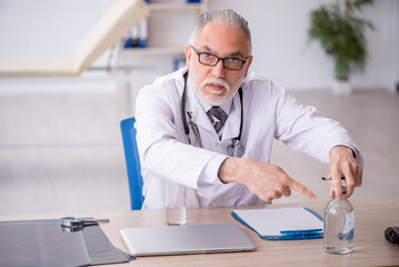 Old male doctor working in the clinic