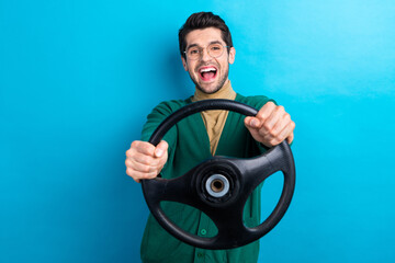 Photo of positive crazy man have good mood hands hold steering wheel isolated on blue color background